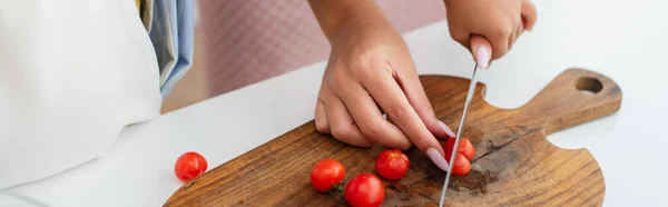 Cropped view of african american woman and kid cutting cherry tomatoes in kitchen, banner — Stock Photo