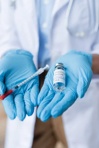 Close up do médico em luvas de látex segurando frasco com vacina e seringa nas mãos — Fotografia de Stock