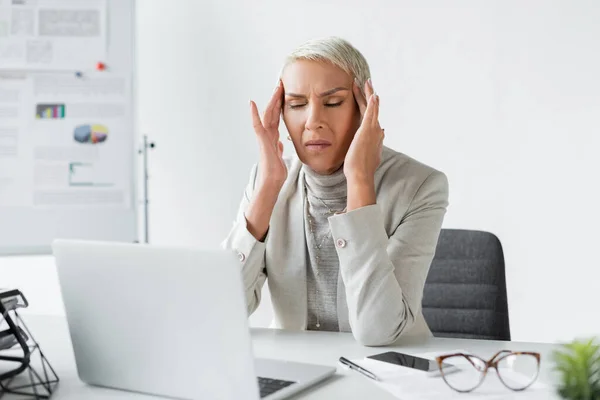 Stanca donna d'affari anziana ad occhi chiusi con emicrania — Foto stock
