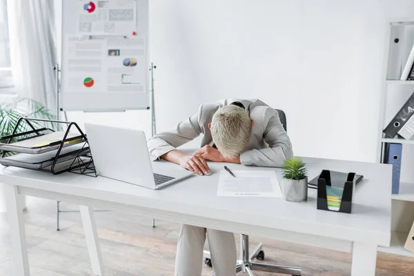 Müde Seniorin liegt Schreibtisch neben Laptop — Stockfoto