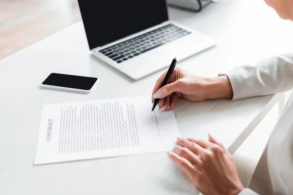 Vista parziale della donna d'affari firma documento vicino gadget — Foto stock