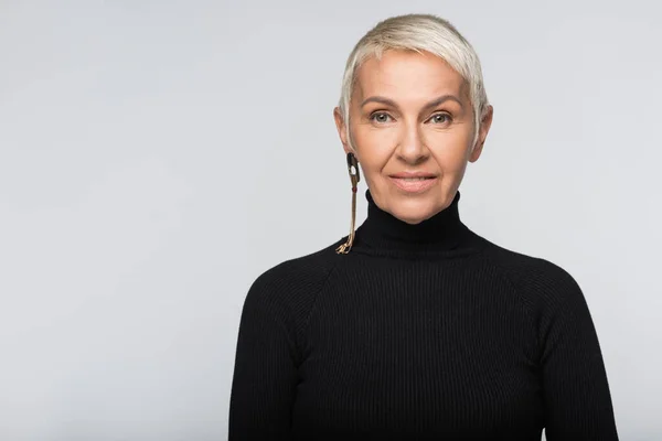 Mujer mayor sonriente en cuello alto negro aislado en gris - foto de stock