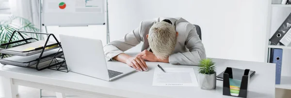 Tired senior businesswoman with grey hair lying on desk near laptop, banner — Stock Photo