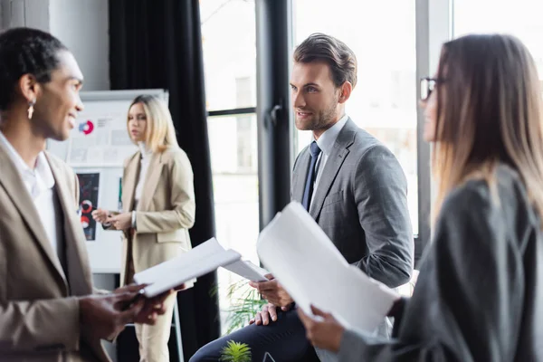 Multiethnic businesspeople holding documents during discussion in office — Stock Photo