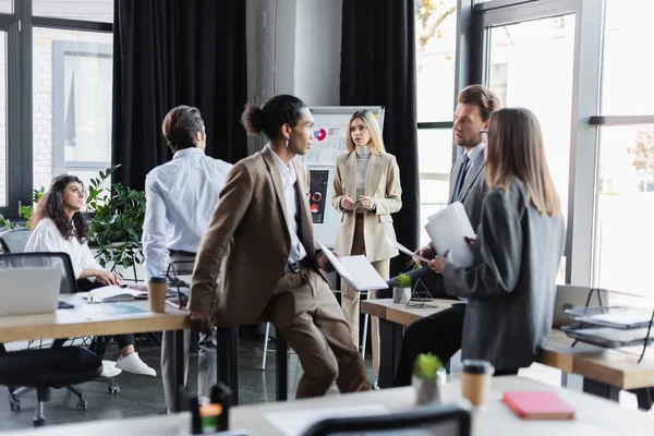 Multiethnic business people with documents talking in office — Fotografia de Stock