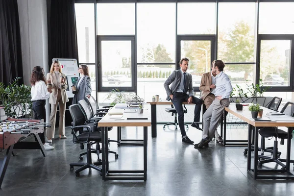 Young business people talking during coffee break in modern office — Fotografia de Stock