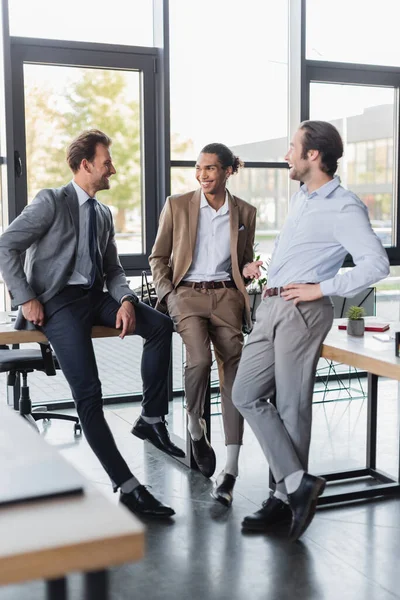 Positiver afrikanisch-amerikanischer Geschäftsmann gestikuliert im Gespräch mit Amtskollegen — Stockfoto