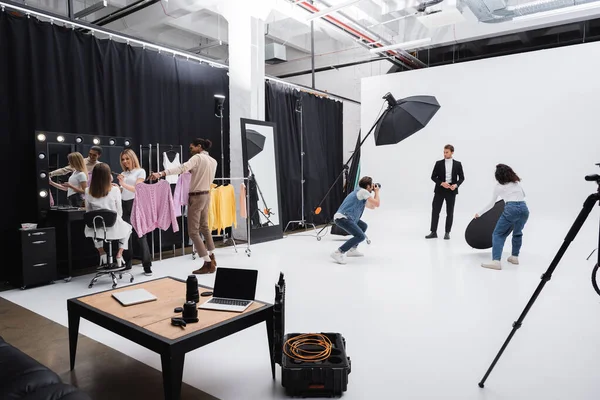 Équipe multiethnique travaillant avec des modèles professionnels pendant la séance photo — Photo de stock