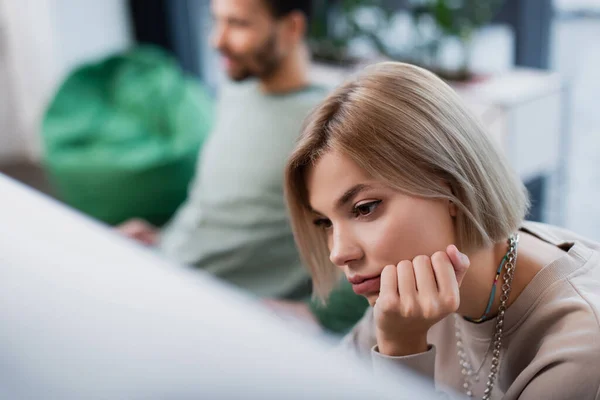 Нудна блондинка менеджер працює біля розмитих афроамериканських колег — стокове фото