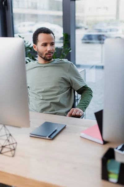 Homem americano africano olhando para monitor de computador no escritório — Fotografia de Stock