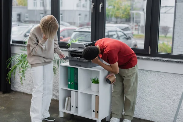 Multiethnische Kollegen betrachten modernen Kopierer im Büro — Stockfoto