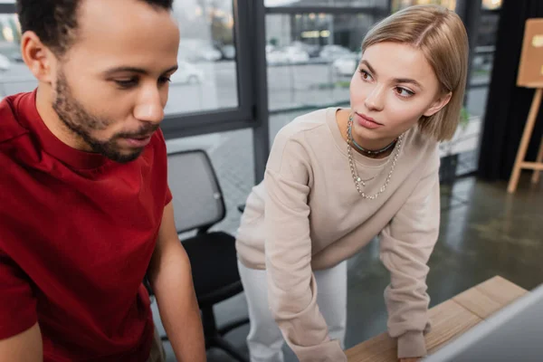 Blonde Geschäftsfrau blickt auf afrikanisch-amerikanische Kollegin — Stockfoto