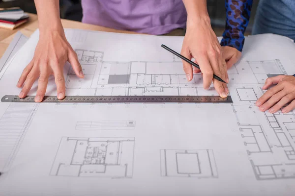 Cropped view of interior designers working with blueprint — Stock Photo