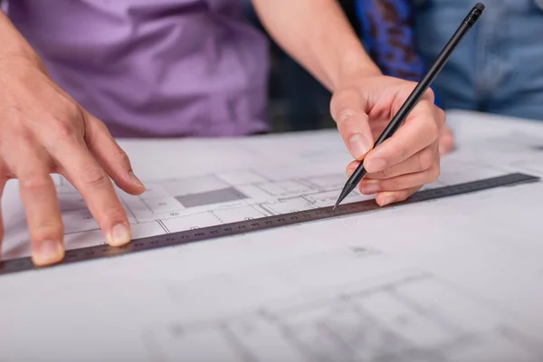 Cropped view of interior designer holding pencil and ruler while working with blueprint — Stock Photo