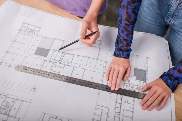 High angle view of interior designers holding ruler and pencil near blueprint — Stock Photo