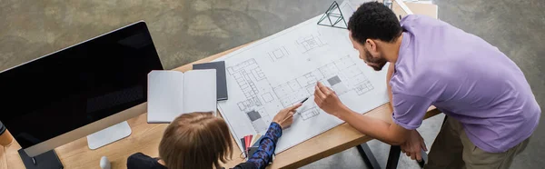 Top view of multiethnic interior designers discussing blueprint near color samples, banner — Stock Photo