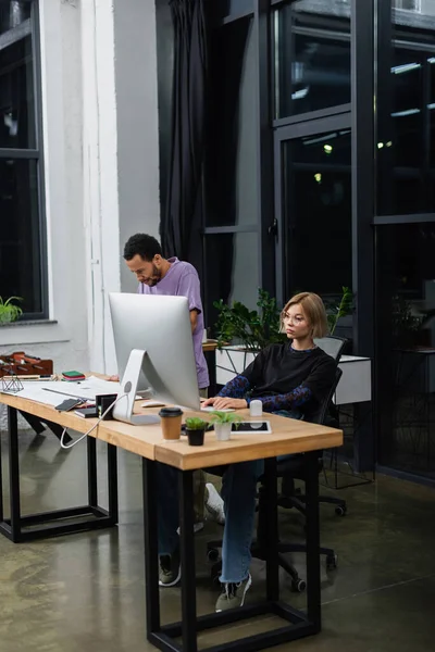 Young multiethnic colleagues working on start up in modern office — Stock Photo