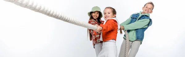 Preteen children pulling rope while playing tug of war game on white, banner — Stock Photo