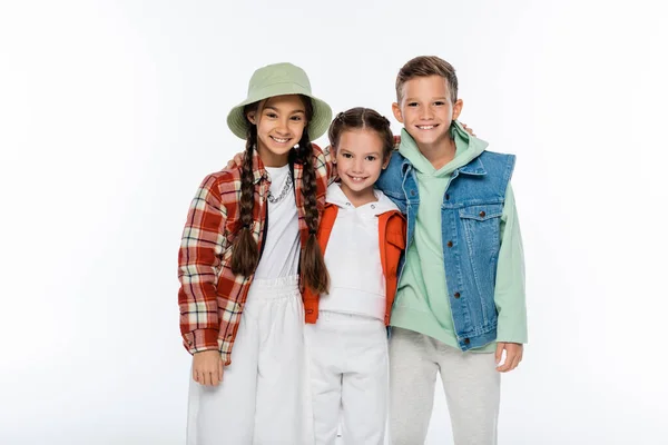 Cheerful boy and stylish girls looking at camera isolated on white — Stock Photo