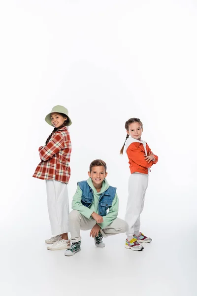 Full length of stylish kids smiling while posing on white — Stock Photo