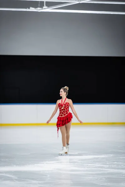 Piena lunghezza di felice giovane donna con medaglia pattinaggio artistico in arena di ghiaccio professionale — Foto stock