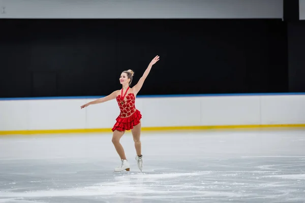 Comprimento total da mulher alegre com medalha de patinação artística na arena de gelo profissional — Fotografia de Stock