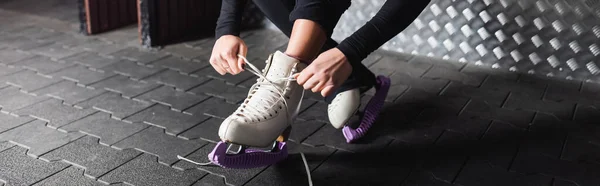 Jeune femme attachant des lacets sur des chaussures de patinage artistique, bannière — Photo de stock