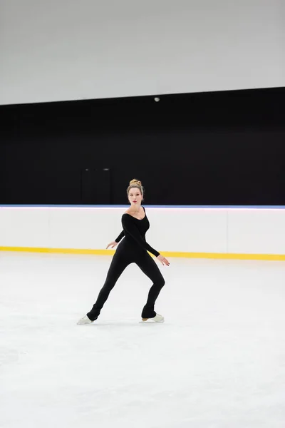 Longitud completa de patinador artístico profesional en bodysuit patinaje en pista de hielo - foto de stock