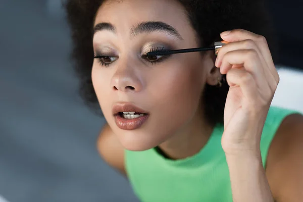 Pretty african american woman applying mascara at home — Stock Photo