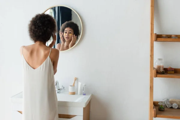 Unscharfe Afroamerikanerin trägt Augenklappen im Badezimmer auf — Stockfoto