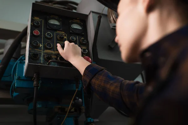 Low angle view of blurred welder switching welding machine in factory — Stock Photo