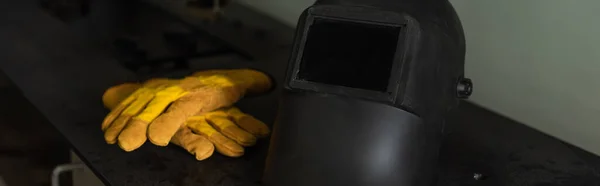 Guanti di saldatura e casco sul tavolo in fabbrica, banner — Foto stock