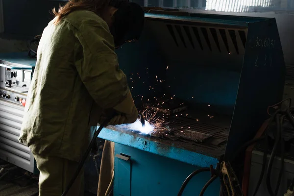 Brunette soudeuse travaillant avec torche de soudage en usine — Photo de stock