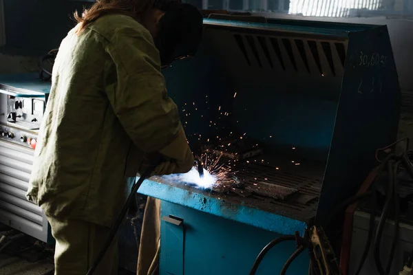 Soldador morena trabajando con antorcha de soldadura en fábrica - foto de stock