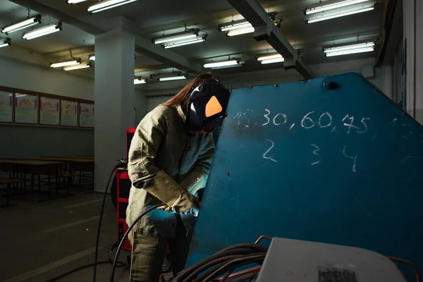 Soldador en casco protector que trabaja en fábrica - foto de stock