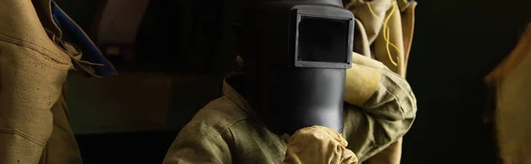 Welder in safety mask and gloves standing in dressing room of factory, banner — Stock Photo