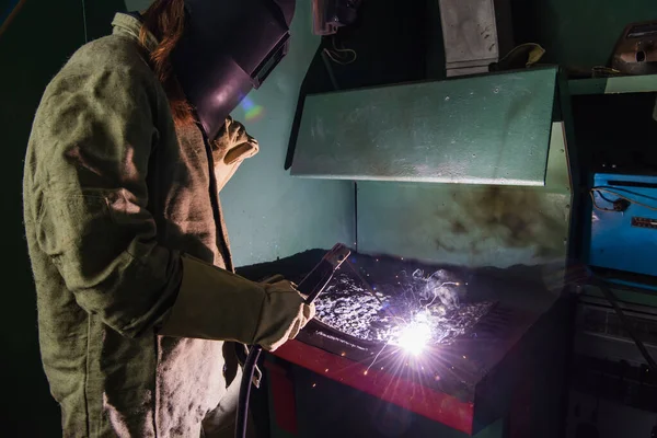 Welder in mask with visor working with welding torch in factory — Foto stock