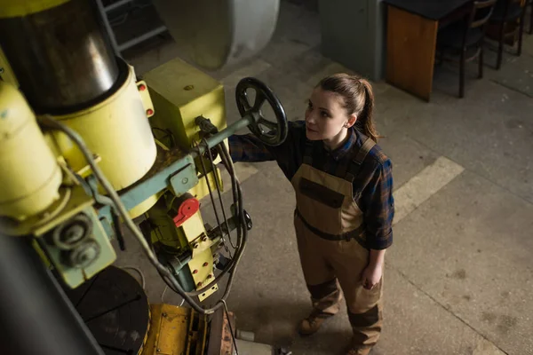 Vue aérienne du jeune soudeur travaillant avec une machine à souder en usine — Photo de stock