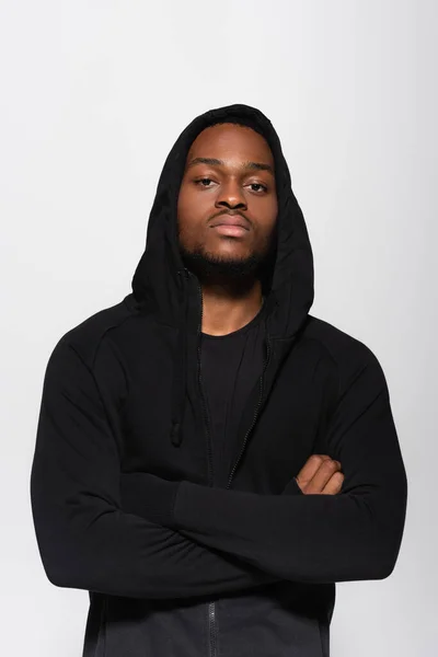 Молодий афроамериканський чоловік в светрі стоїть з схрещеними руками ізольовано на сірому — стокове фото