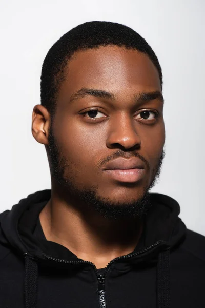 Афроамериканський чоловік в светрі дивиться на камеру ізольовано на сірому — стокове фото