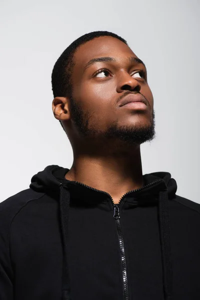 Афроамериканський чоловік в светрі дивиться ізольовано на сірому — стокове фото