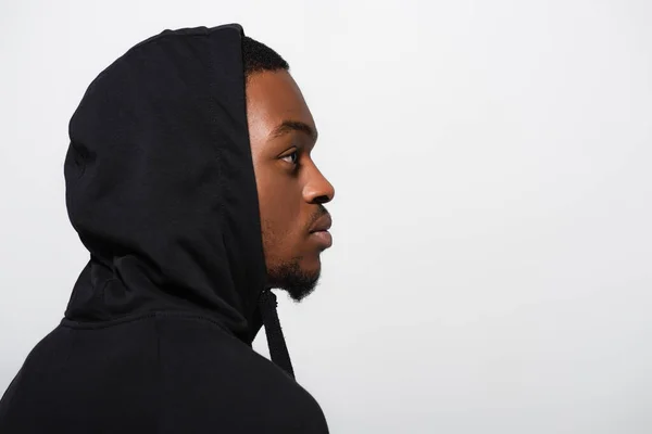 Side view of young african american man in hoodie isolated on grey — Stock Photo