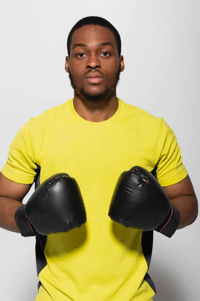 Young african american sportsman in boxing gloves isolated on grey — Stock Photo