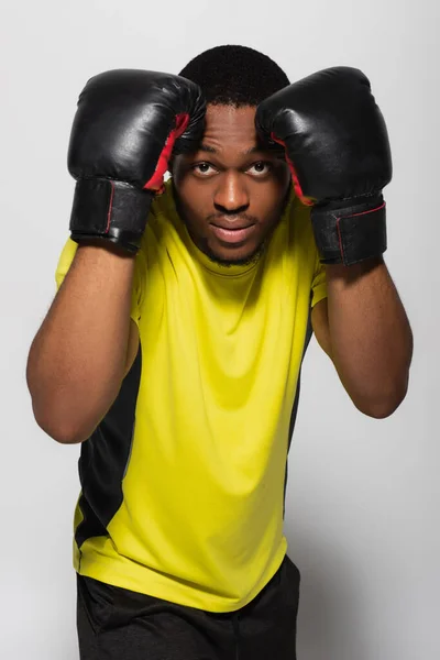 Esportista afro-americano trabalhando em luvas de boxe isoladas em cinza — Fotografia de Stock