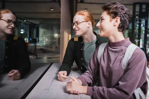 Young couple with backpacks standing near hotel reception — Stock Photo