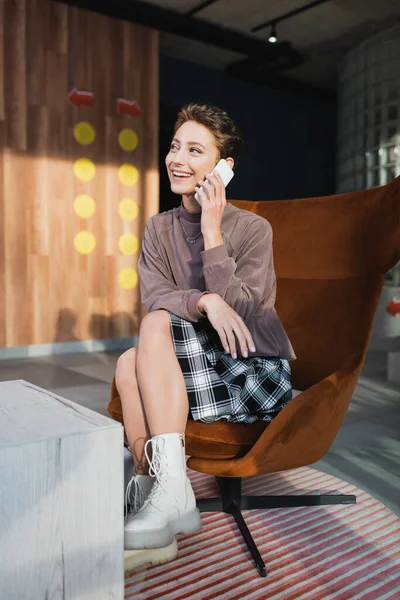 Smiling woman talking on cellphone in hotel lobby — Stock Photo