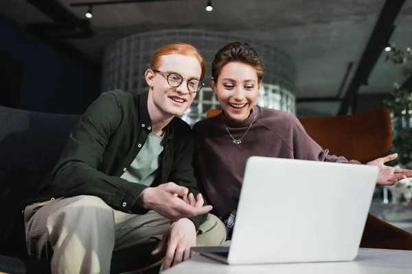 Casal positivo ter chamada de vídeo no laptop no hotel — Fotografia de Stock