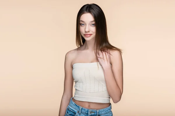 Pleased young woman in crop top with bare shoulders isolated on beige — Fotografia de Stock