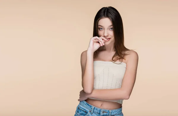 Flirty young woman in crop top with bare shoulders isolated on beige — Foto stock