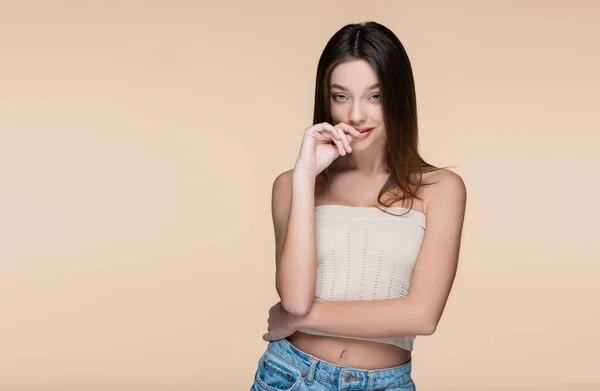 Flirty giovane donna in crop top con spalle nude isolato su beige — Foto stock